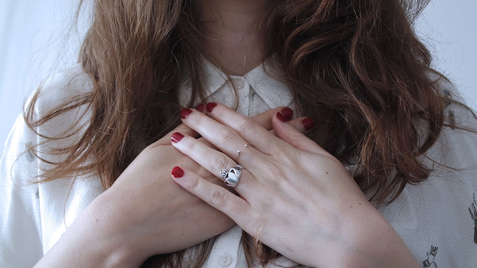 Photo by Giulia Bertelli woman wearing silver-colored ring HER HANDS are on her heart
