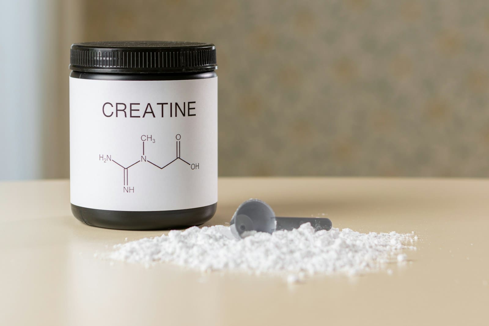Photo by Aleksander Saks a bottle of creatine next to a spoon on a table
