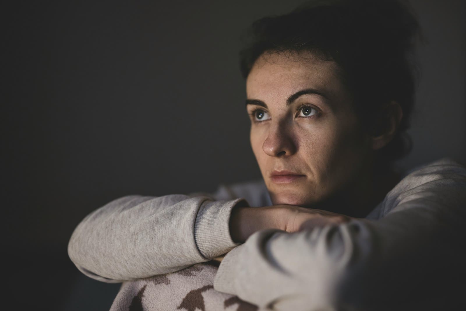 Photo by engin akyurt woman in gray long sleeve shirt, she rests her head on her folded arms
